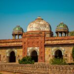 Isa Khan's Tomb with intricate architecture under a clear blue sky in Delhi, India.