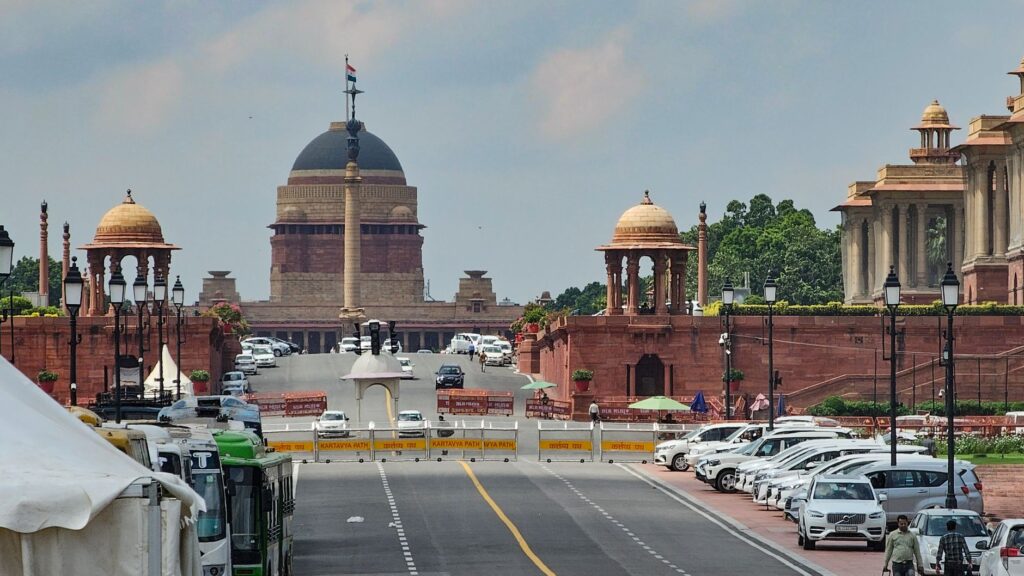View of Rashtrapati Bhavan entrance and surrounding architecture with traffic.