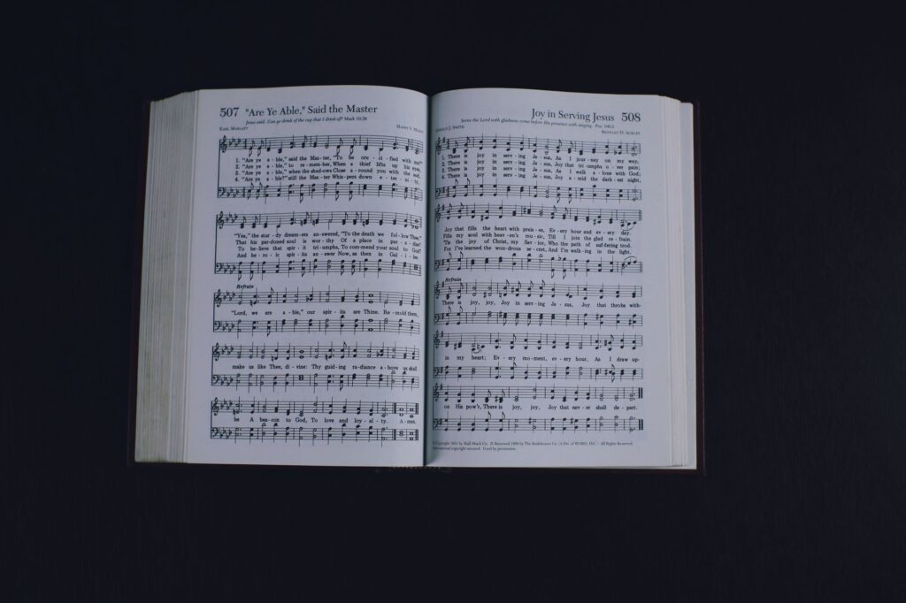 From above of pages of opened book with music notes placed on black background