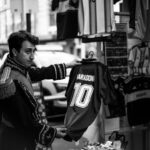 Street vendor holds a Maradona jersey in Buenos Aires. Black and white photograph with a vintage vibe.