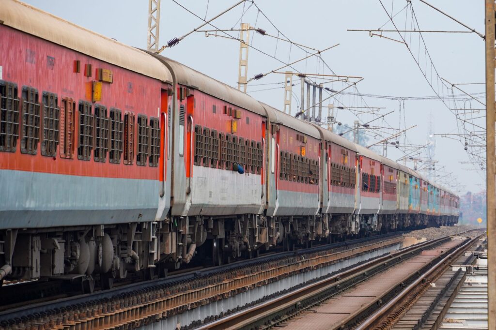 A passenger train traveling on elevated tracks, showcasing the Indian Railway system.