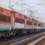 A passenger train traveling on elevated tracks, showcasing the Indian Railway system.