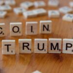 Scrabble tiles spelling 'TRUMP' on a wooden table, creating a political theme.
