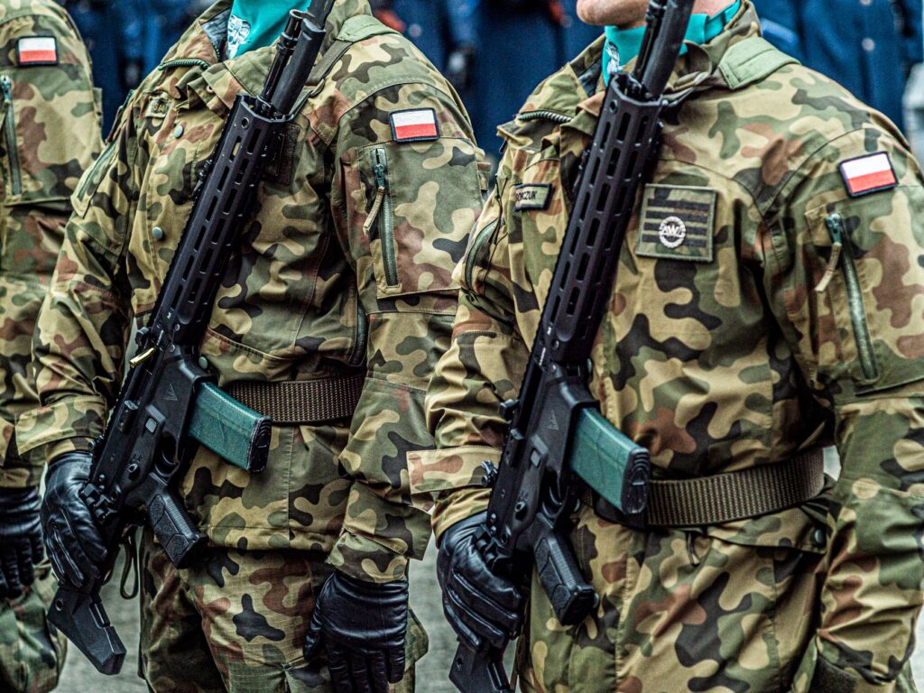 Polish soldiers in uniform standing in formation with rifles, showcasing military discipline.