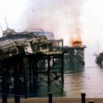 Smoke and fire engulf the historic West Pier in Brighton, showcasing disaster and decay.