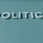 Close-up image of the word 'Politics' against a teal green background, highlighting political themes.
