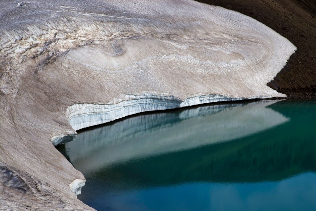 Stunning icy shoreline of a lake in Iceland reflecting pristine snow and ice formations.