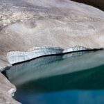 Stunning icy shoreline of a lake in Iceland reflecting pristine snow and ice formations.