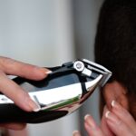 A detailed view of a hair clipper being used to cut hair. Ideal for grooming and barbering concepts.