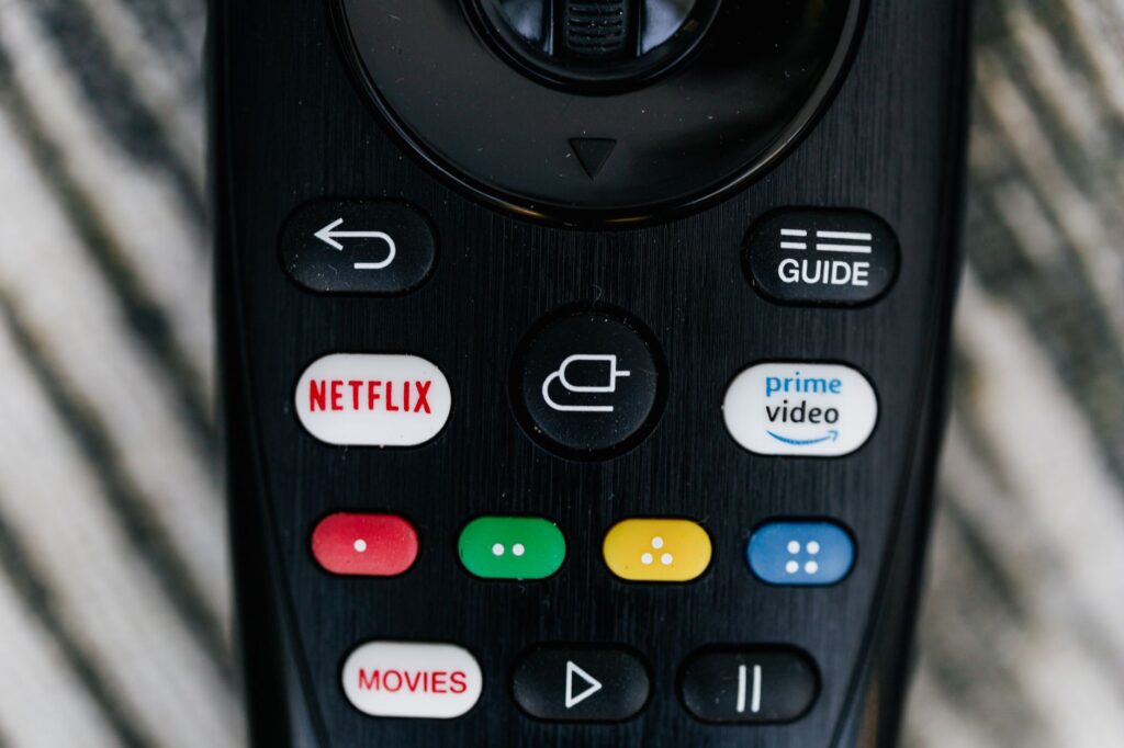 Detailed close-up image of a TV remote control with streaming service buttons.