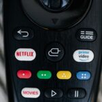 Detailed close-up image of a TV remote control with streaming service buttons.