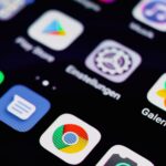 Close-up image of a smartphone screen displaying various app icons on a dark background.