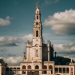 Majestic view of the Sanctuary of Our Lady of Fátima with cumulus clouds in the backdrop.