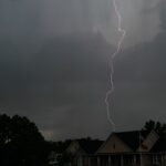 A striking lightning bolt pierces the stormy sky over suburban houses in North Carolina.