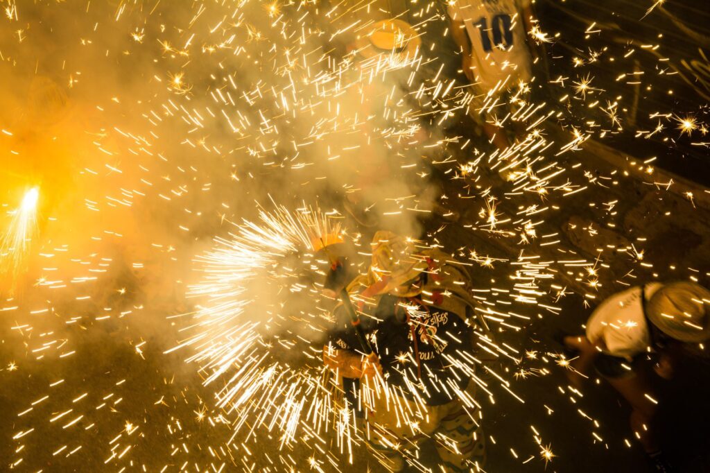 Colorful fireworks bursting in celebration during a vibrant night festival.