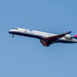 A commercial airplane of IBEX Airlines in flight against a bright blue sky, showcasing aviation travel.