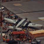 A detailed miniature scene of airplanes and people at a crowded airport display.
