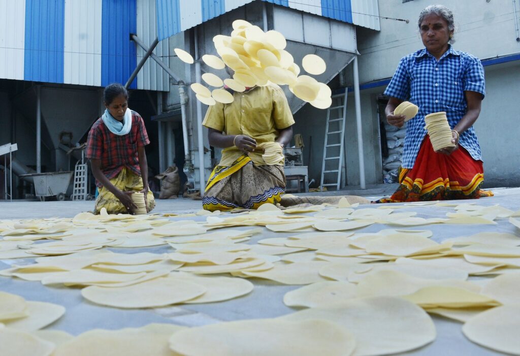 Traditional papadum preparation by women in Madurai, India.