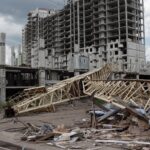 An urban construction site featuring a collapsed crane and unfinished buildings under cloudy skies.