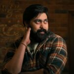 Captivating portrait of a bearded man in a plaid shirt indoors, exuding a thoughtful demeanor.