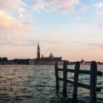 Scenic view of Venice's skyline featuring St. George's Church across the bay during sunset.