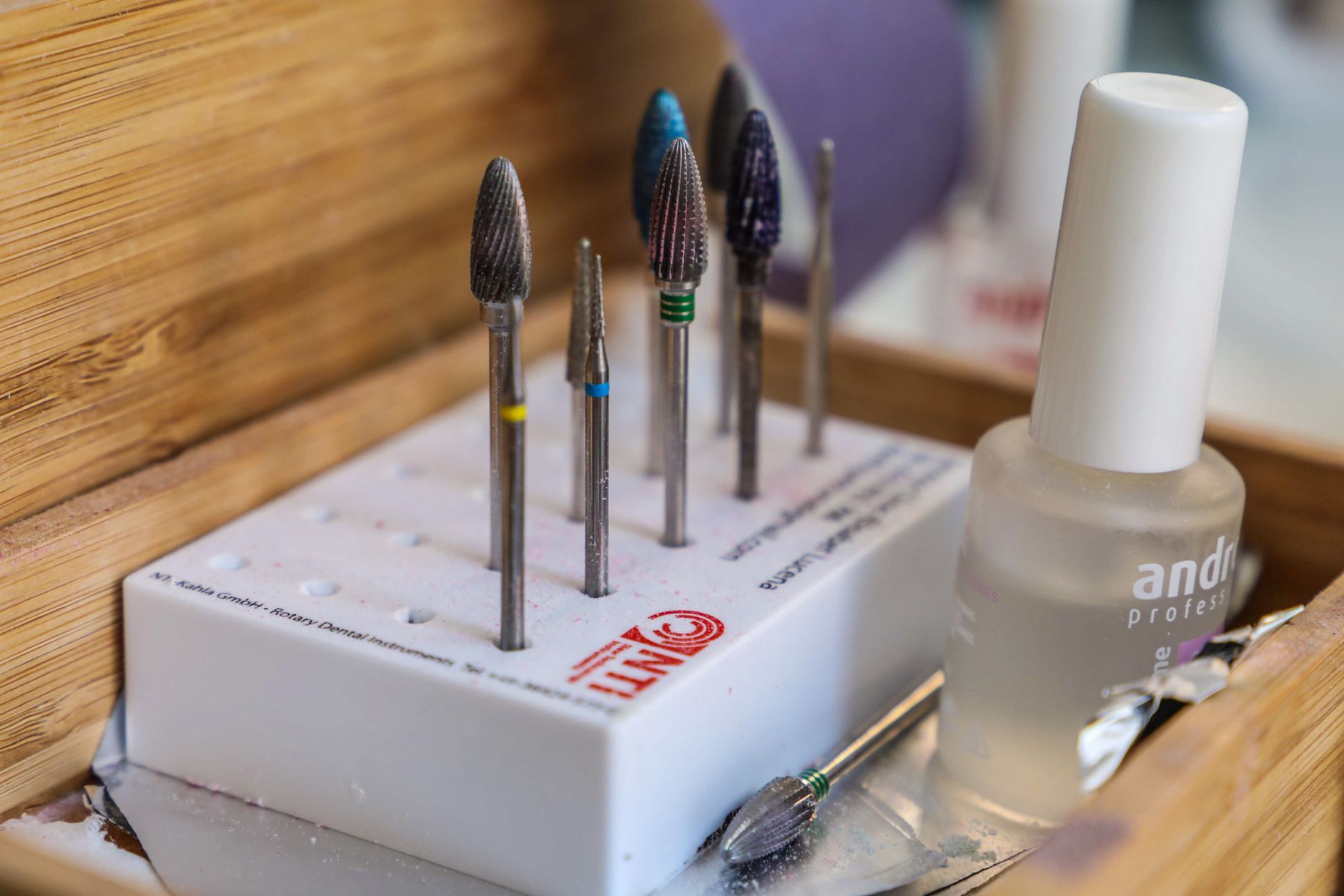 Detailed view of manicure drill bits and polish for nail care.
