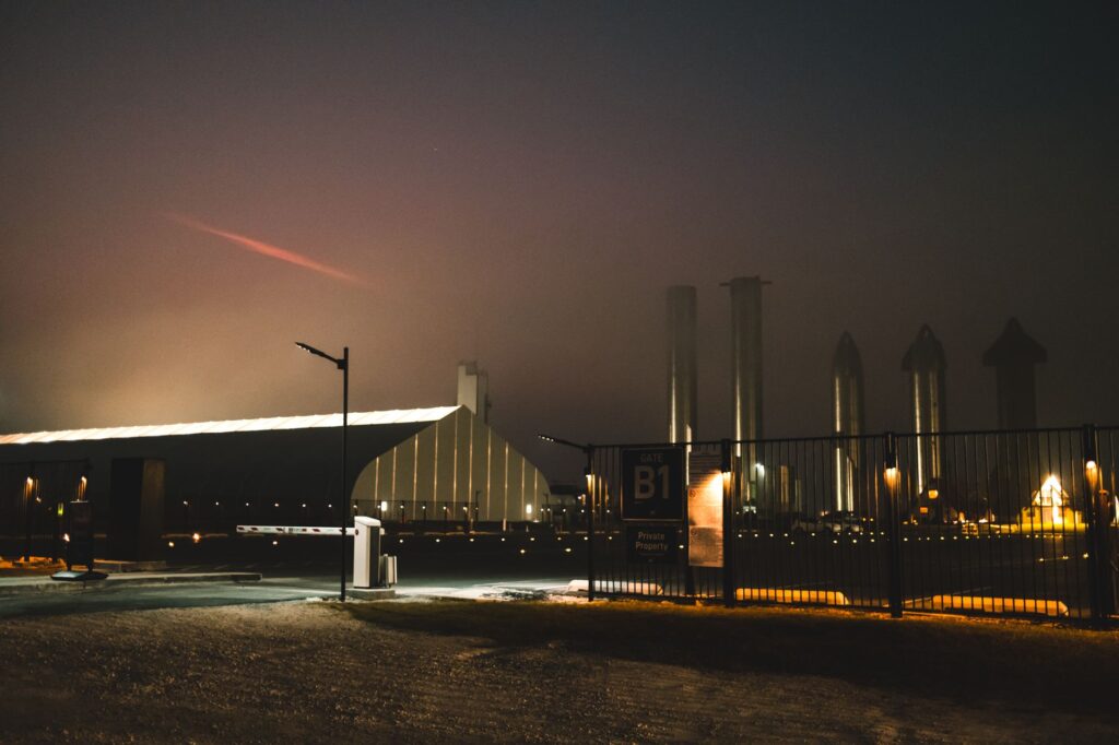 Dramatic night view of SpaceX facility with fog and lights in Brownsville, Texas.