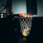 Dramatic basketball dunk captured in Abu Dhabi sports arena.