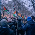 A peaceful protest in Berlin featuring Palestinian flags and diverse participants.