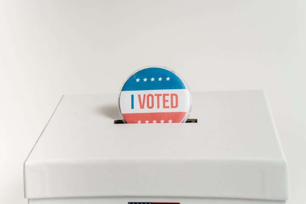 Close-up of an I Voted badge on a ballot box, symbolizing voting in the USA elections.