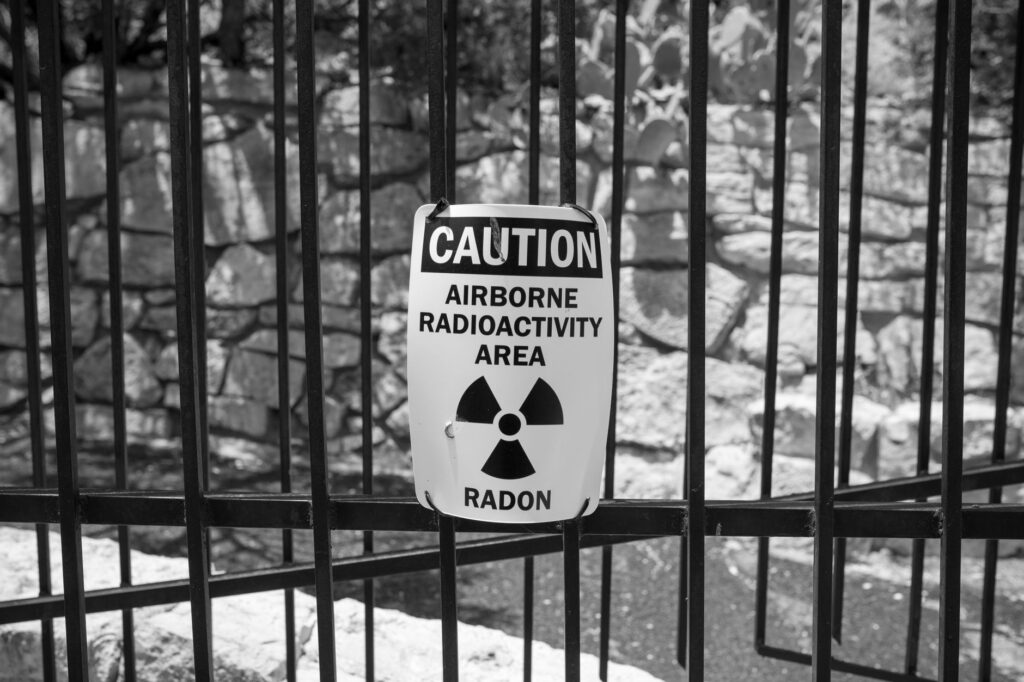 Black and white image of a caution sign warning of airborne radioactivity and radon.