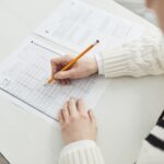 Close-up of a student filling out a multiple-choice exam in a quiet classroom setting.