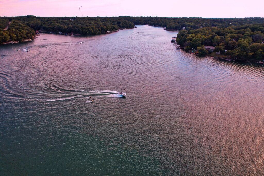 A stunning aerial view of boats gliding on a serene lake in Mound City, Kansas, surrounded by lush greenery.