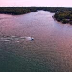 A stunning aerial view of boats gliding on a serene lake in Mound City, Kansas, surrounded by lush greenery.