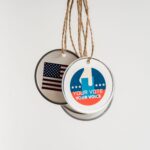 Close-up view of USA voting badges hanging on strings against a white background.