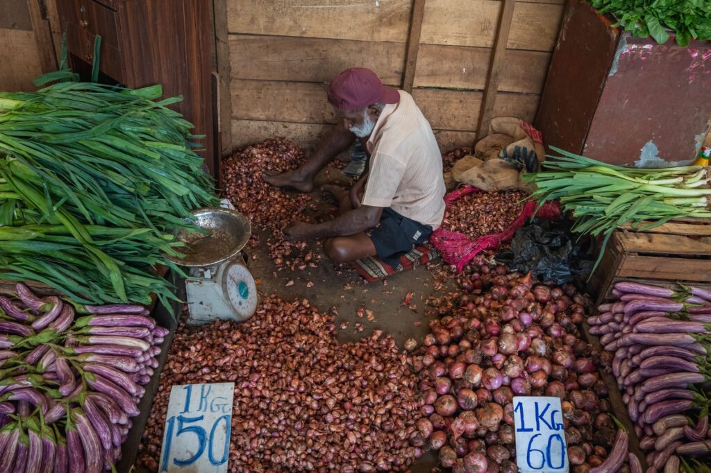 An elderly vendor selling vegetables at a market in Colombo, Sri Lanka.
