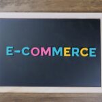 Colorful letters spelling 'e-commerce' on a wooden framed blackboard.