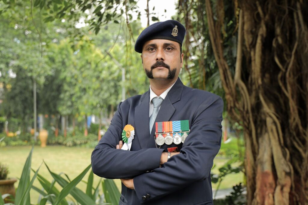 A police officer in uniform proudly displays his medals in a serene outdoor setting, exuding authority.