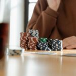 Casual poker scene with colorful poker chips and playing cards on a wooden table.
