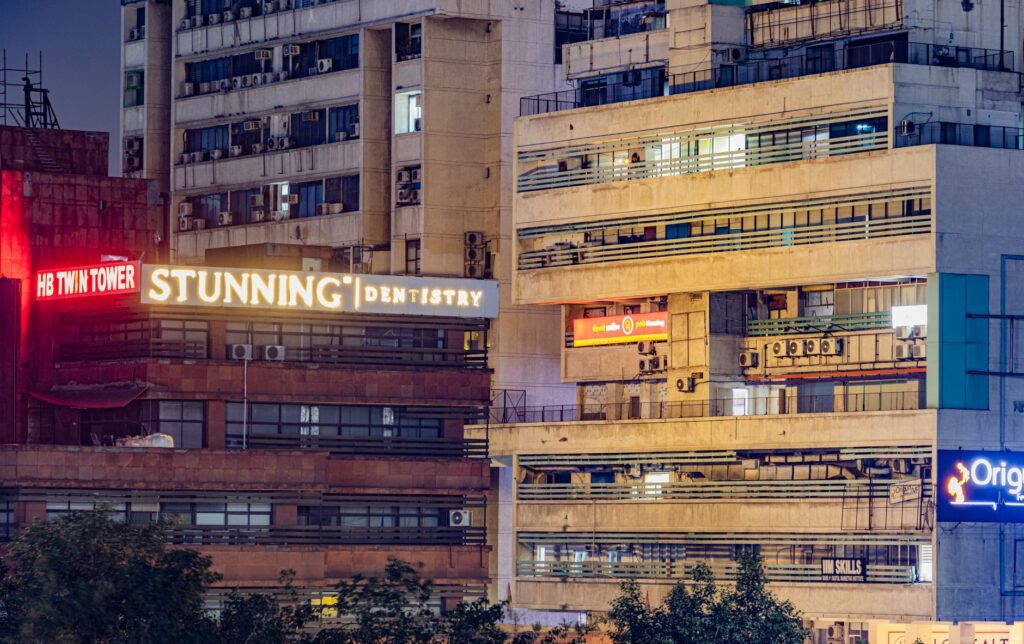 A captivating night view of Delhi's modern urban buildings illuminated by neon signs.