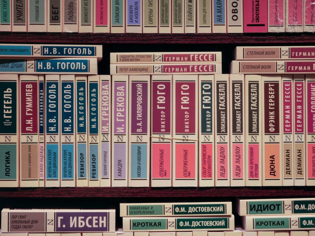 A vibrant collection of Russian literature books in various colors arranged on a bookshelf.