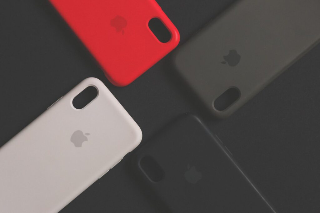 Four colorful smartphone cases on a dark surface, showcasing variety and design.