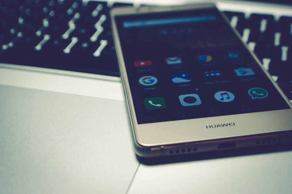 Close-up of a smartphone placed on a laptop keyboard, highlighting digital interaction.