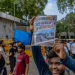 Protesters congregate at Jantar Mantar, New Delhi, holding up signs for peaceful demonstration.