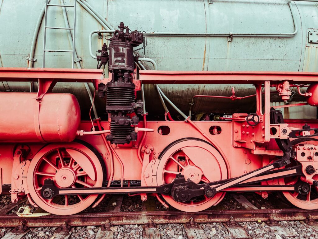 Detailed close-up of a vintage steam locomotive's wheels and mechanical parts. Industrial and historical charm.