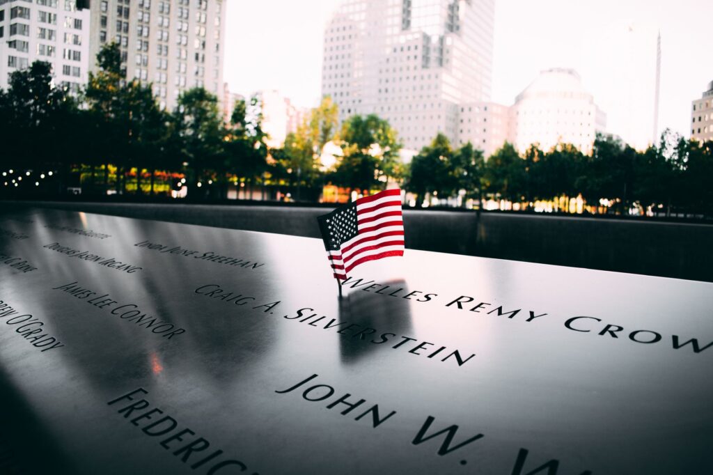 American flag displayed on a memorial at dusk in New York City, symbolizing remembrance and tribute.