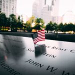 American flag displayed on a memorial at dusk in New York City, symbolizing remembrance and tribute.