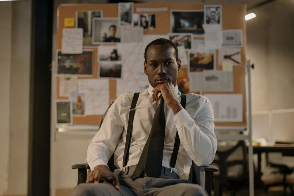 Focused detective in a modern office setting, analyzing a crime board. Cinematic and intense mood.