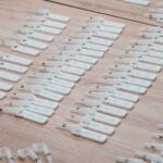 Multiple COVID-19 test kits displayed neatly on a wooden table indoors.