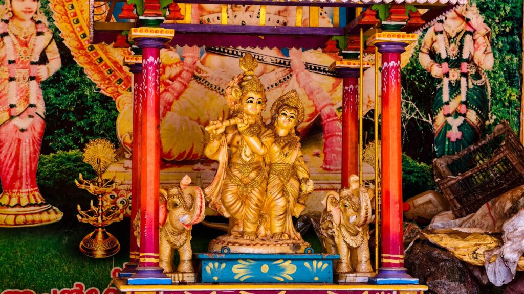 Colorful Radha Krishna shrine featuring elephant figurines and intricate details, symbolizing spiritual art.